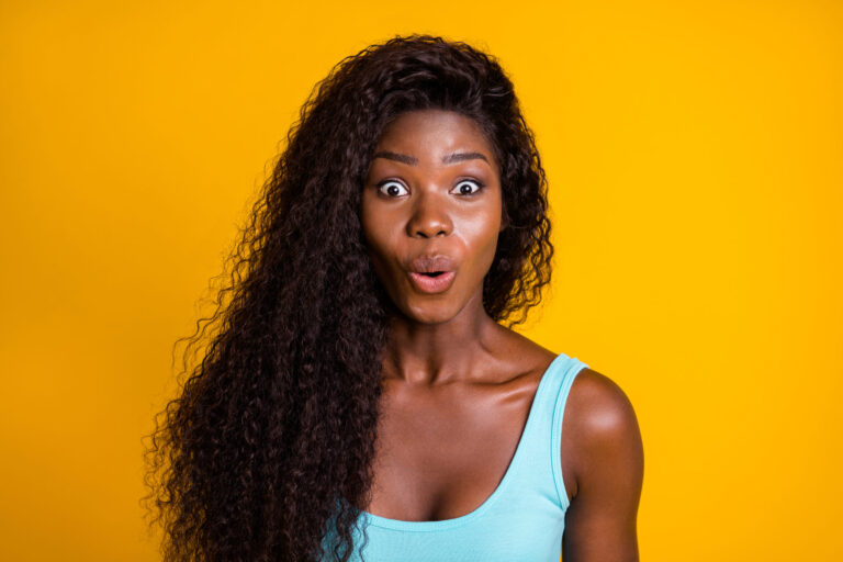 Photo portrait of surprised african american woman wearing blue singlet isolated on vivid yellow colored background